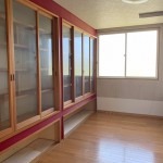1F洋室。壁一面の造付のガラス戸付書棚。お気に入りの物を飾っても埃から守ります。